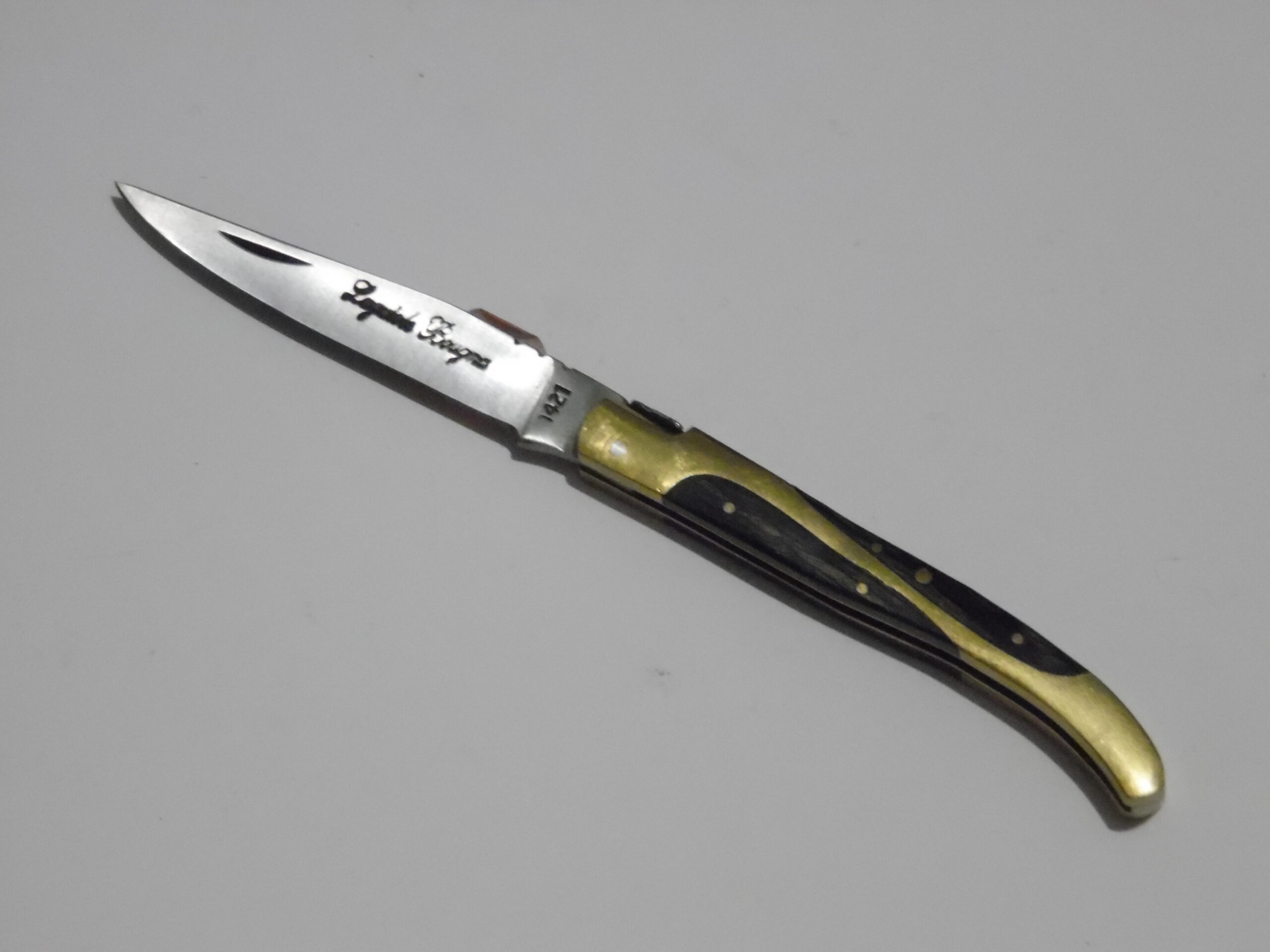 Marque : Laguiole Collection : Bougna Modèle : Acier 1421 Particularité : Manche en laiton monté sur bois Dimension : 16 cm dont lame 7cm   Prix : 35€